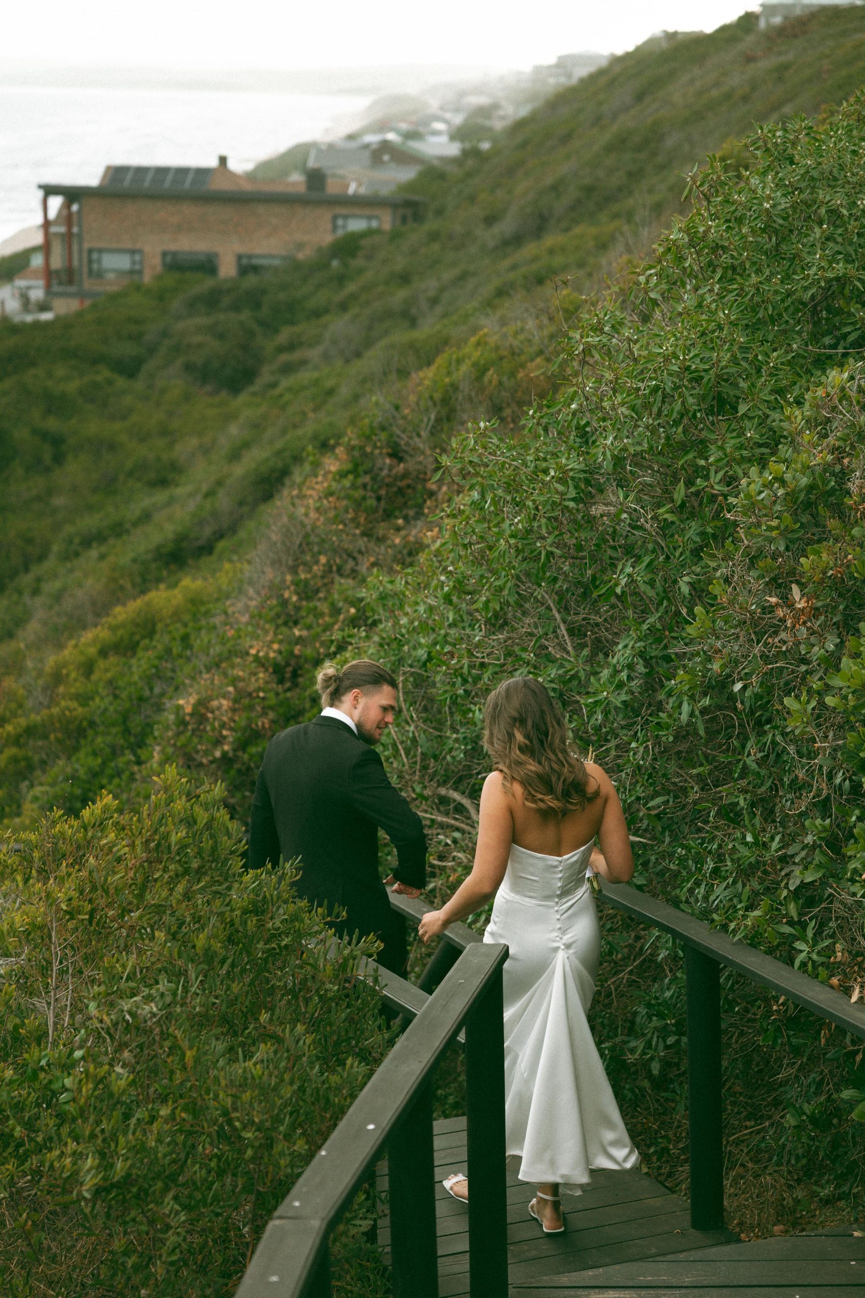 Lily satin strapless wedding dress with draped neckline and button-back detailing.