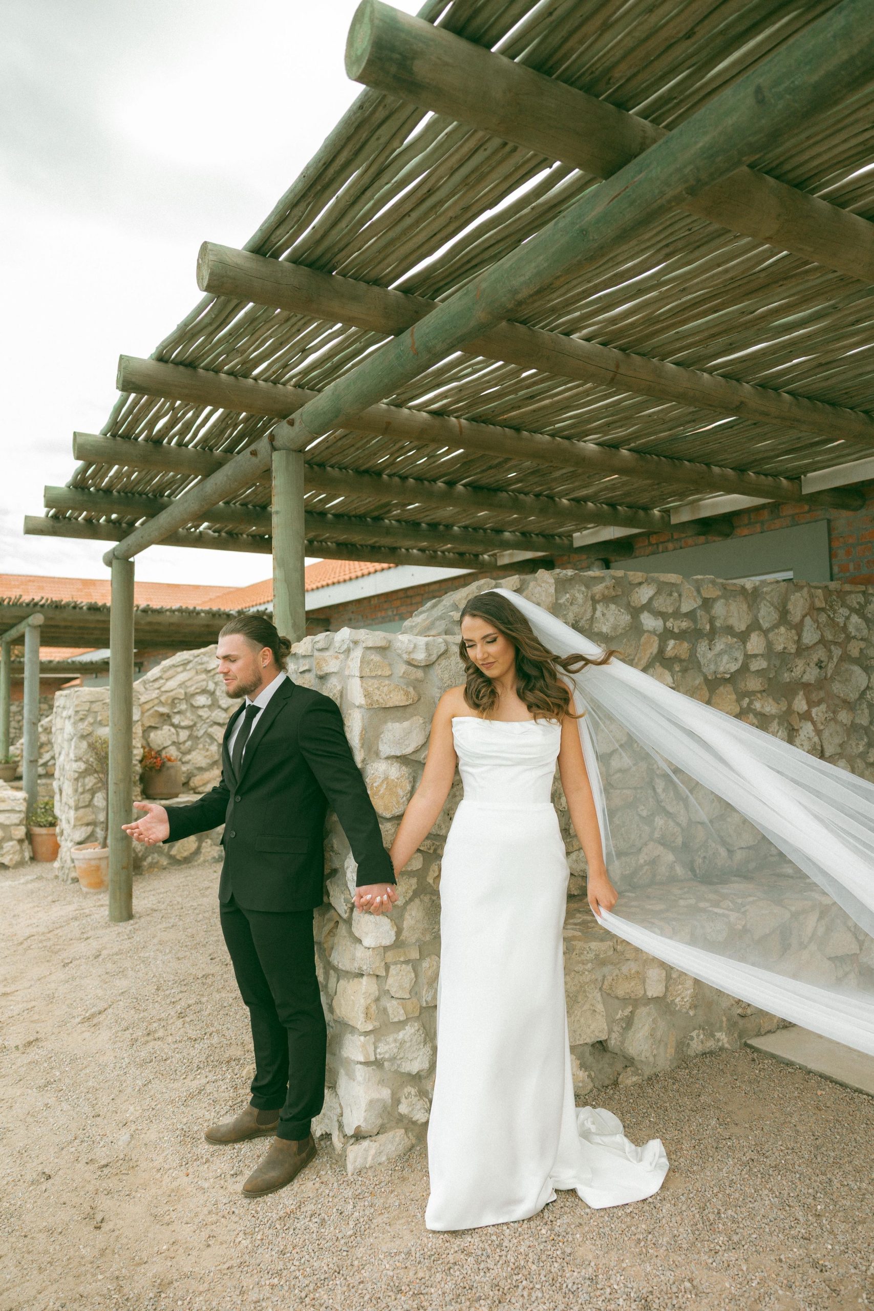 Lily satin strapless wedding dress with draped neckline and button-back detailing.