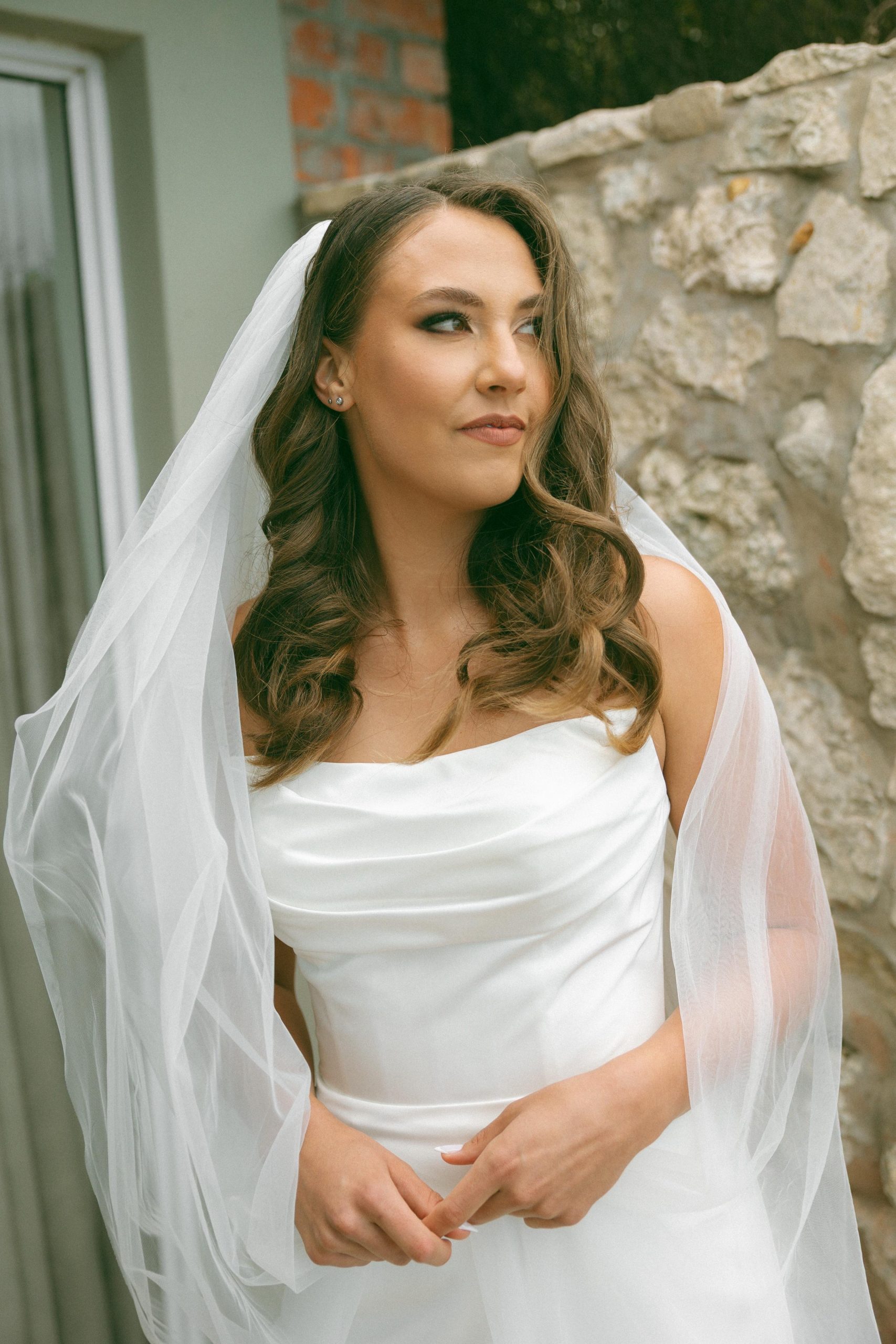 Lily satin strapless wedding dress with draped neckline and button-back detailing.